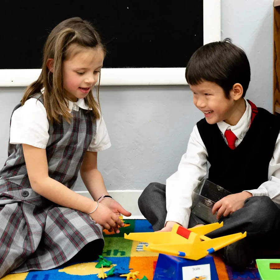 Two students learning together with hands-on materials