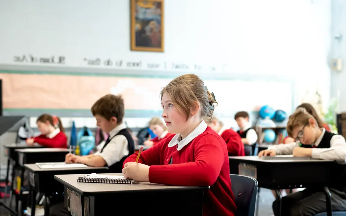 A student attentive at her desk in a Catholic classroom
